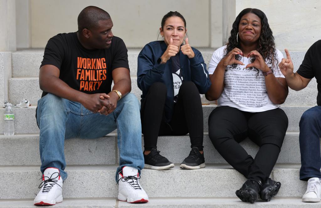 U.S. Rep. Mondaire Jones (D-NY) and Rep. Alexandria Ocasio-Cortez (D-NY) sit on the steps of the U.S. Capitol with Rep. Cori Bush (D-MO) 