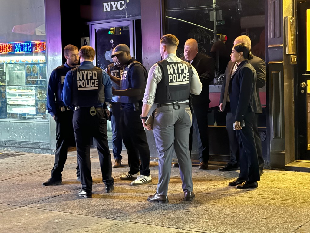 NYPD officers stand near East 96 street and 2nd Avenue following the attack on Paterson and his stepson Friday night.