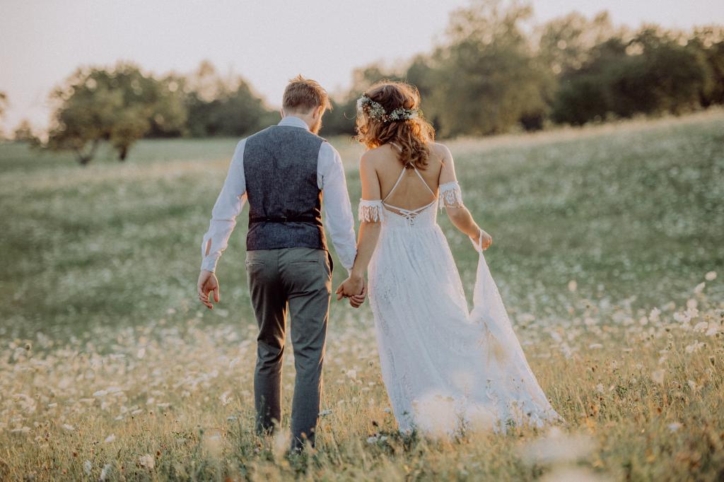 A couple holding hands on their wedding day. 