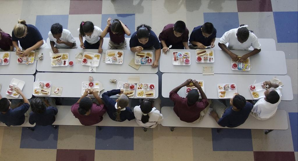 Above view of students eating lunch in cafeteria.