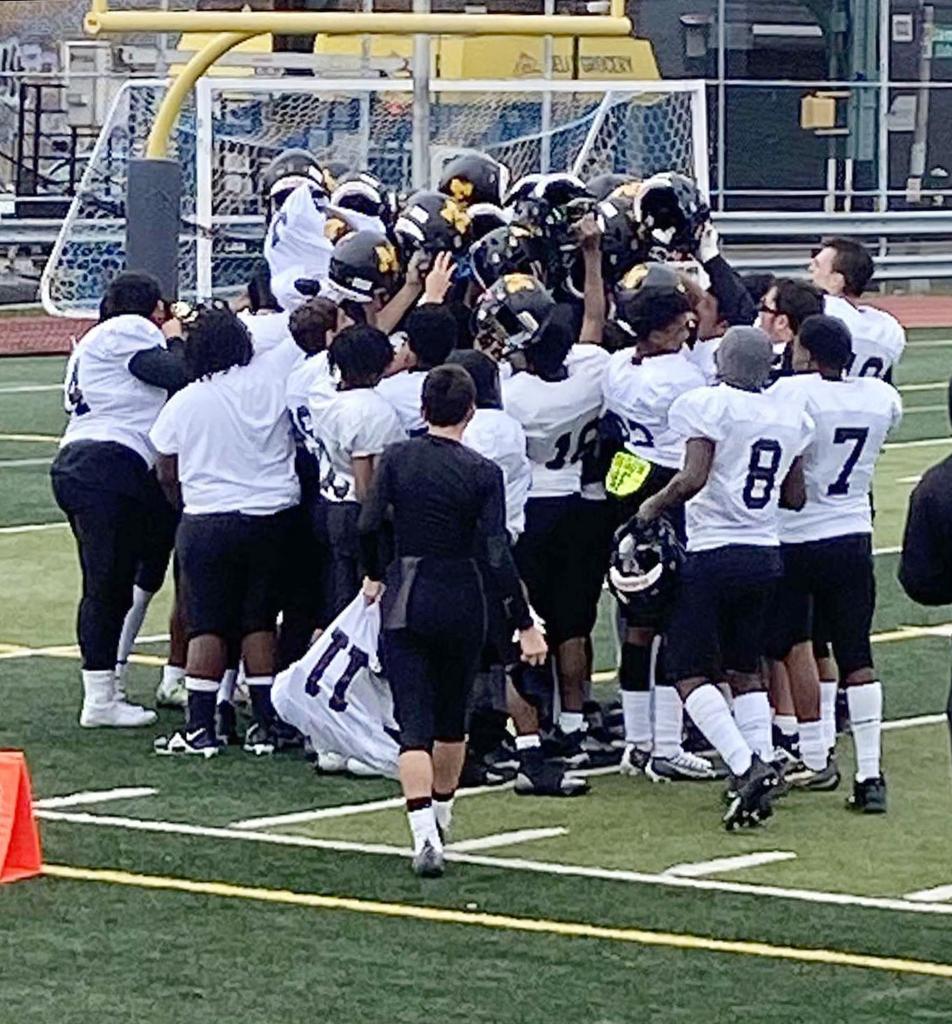 James Madison HS JV Football team huddled on a field with Brian Folkerts and La Parka notably present