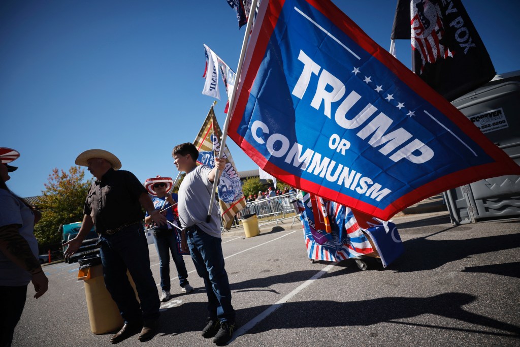 Supporters of Republican presidential candidate Donald Trump selling flags outside his campaign rally venue in Greenville, North Carolina, on October 21, 2024