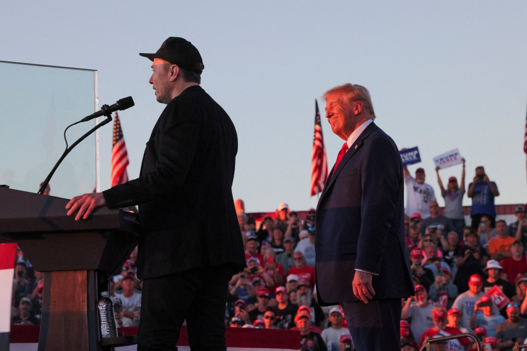 Elon Musk speaks as Former President Donald Trump listens during a rally in Butler, Pa. on Oct. 5, 2024.