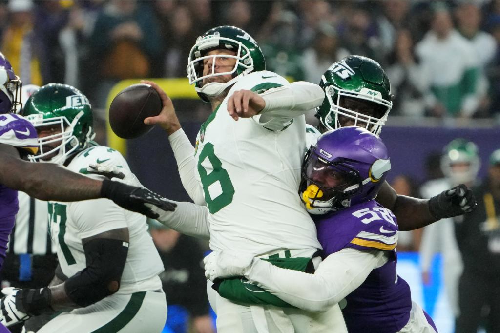 New York Jets quarterback Aaron Rodgers (8) throws the ball under pressure from Minnesota Vikings linebacker Jonathan Greenard (58) in the fourth quarter at Tottenham Hotspur Stadium. 