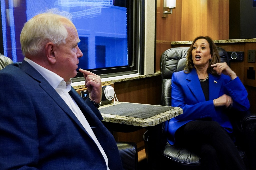 U.S. Democratic vice presidential candidate Minnesota Governor Tim Walz and Democratic presidential candidate and U.S. Vice President Kamala Harris talk at the campaign bus, as Harris and her running mate Walz make a four-stop bus tour of western Pennsylvania before heading to Chicago for the Democratic National Convention, in Rochester, Pennsylvania, U.S., August 18, 2024.