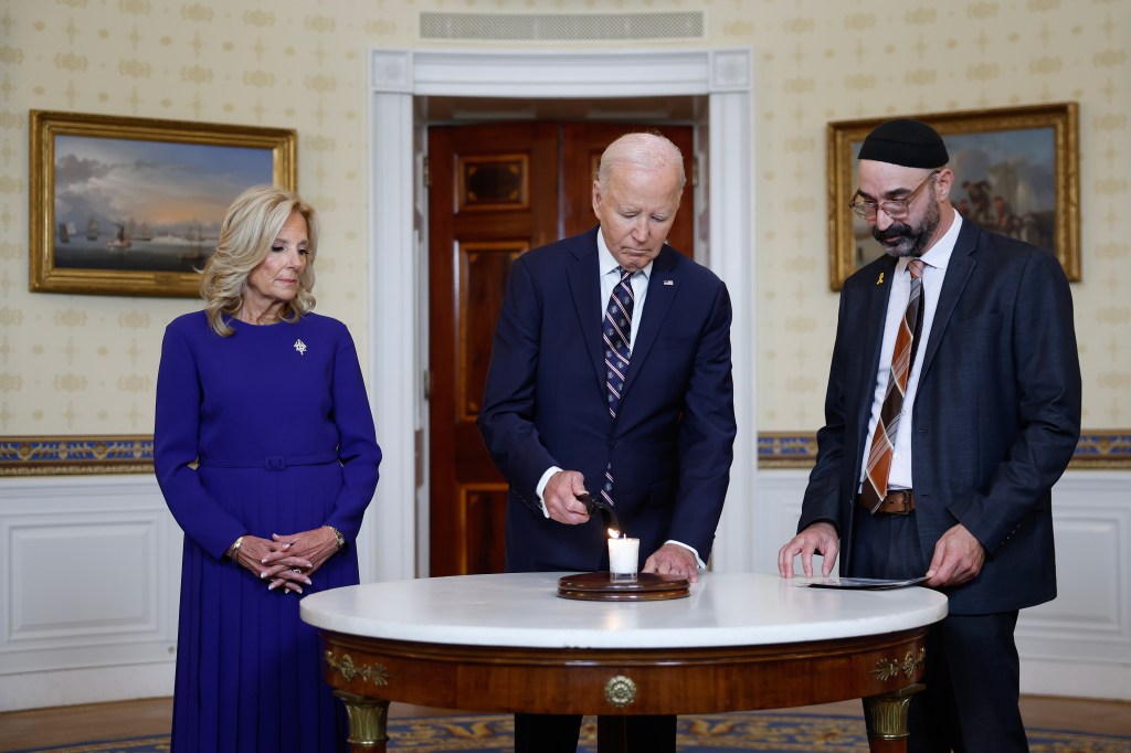 Joe Biden lights a candle during a remembrance ceremony on the one-year anniversary of the Hamas attack on Israel in the Blue Room at the White House on October 07, 2024 in Washington, DC.