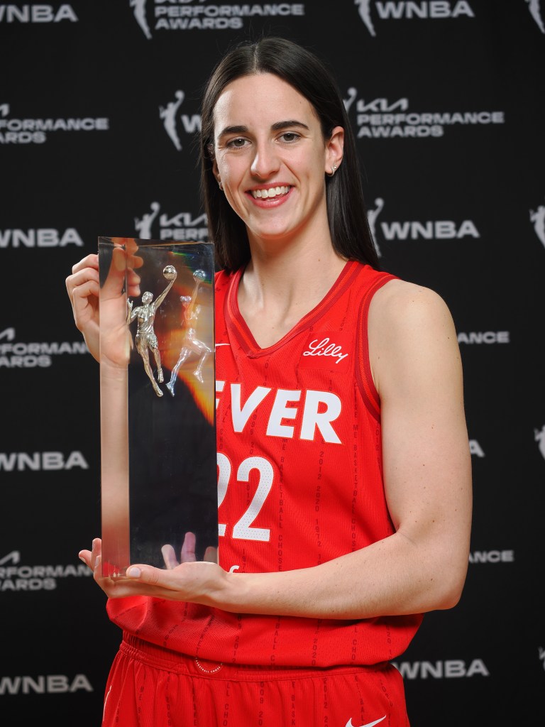 Caitlin Clark poses with her WNBA Rookie of the Year trophy.