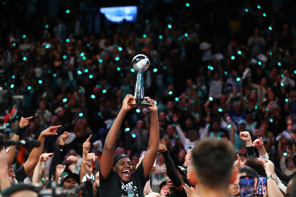 Jonquel Jones of the New York Liberty holding the 2024 WNBA Finals MVP trophy in celebration after victory against the Minnesota Lynx