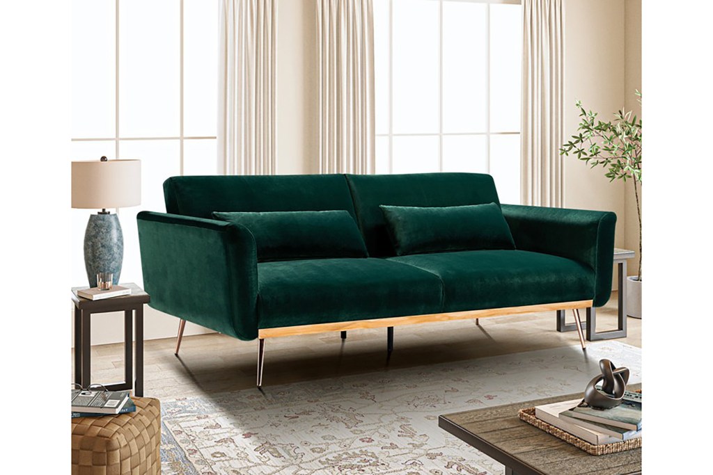 A green velvet couch in a room