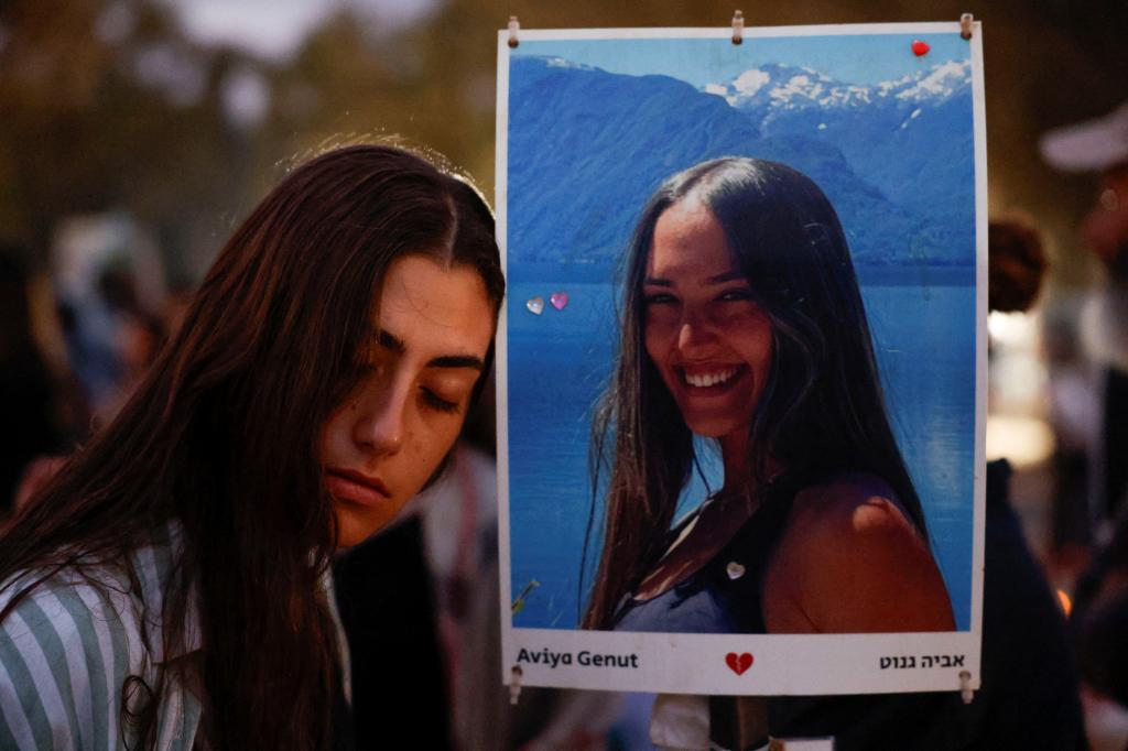 Woman holding a picture at a gathering to mark the anniversary of the deadly October 7 attack by Hamas, at the Nova festival site in Reim, southern Israel