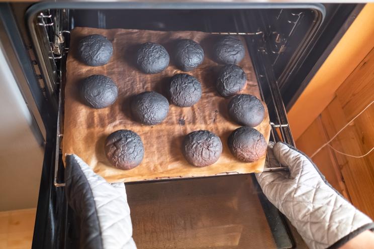 Woman holding a tray of burnt pancakes due to forgetting about preparing dinner