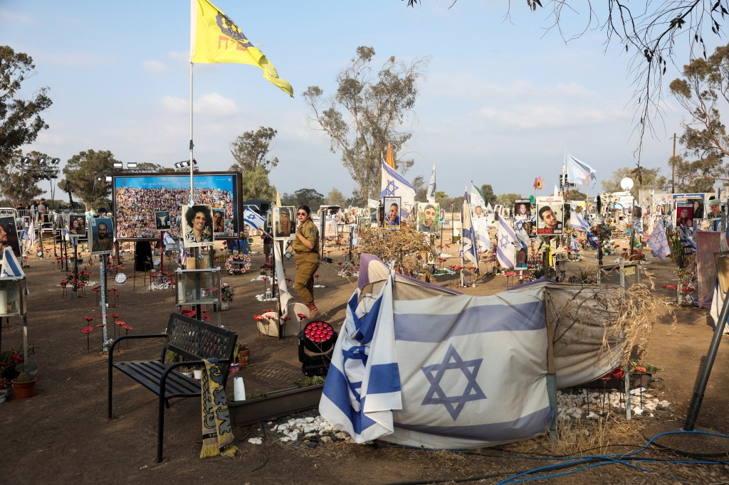 A woman walks, as people visit the site of the Nova festival, where partygoers were killed and kidnapped during the October 7 attack