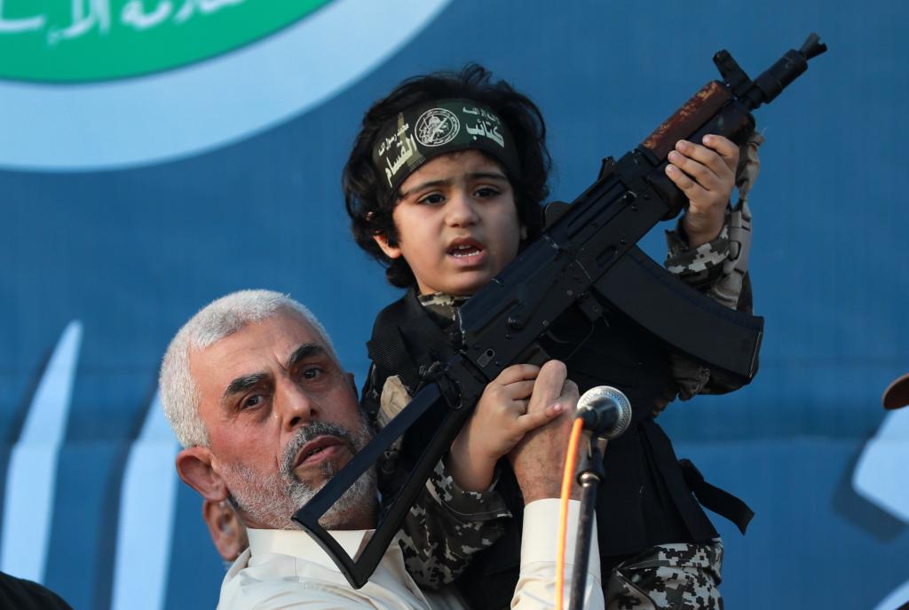 Sinwar holding up a child dressed as a Hamas terrorist in the Gaza Strip on May 24, 2021. 