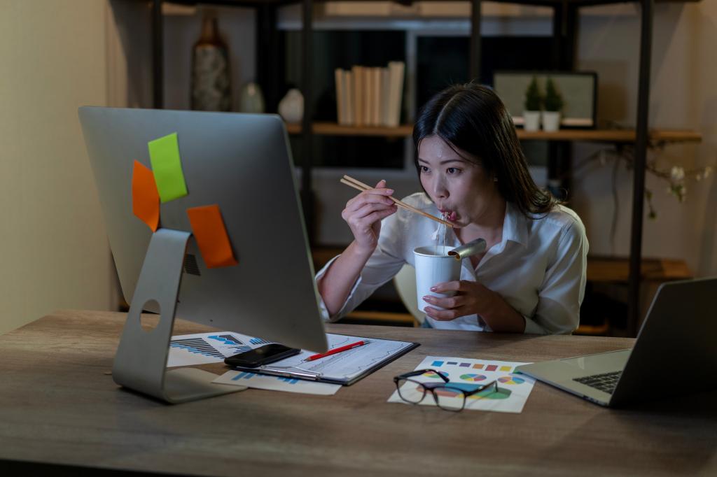 A woman eating lunch in her home office. 