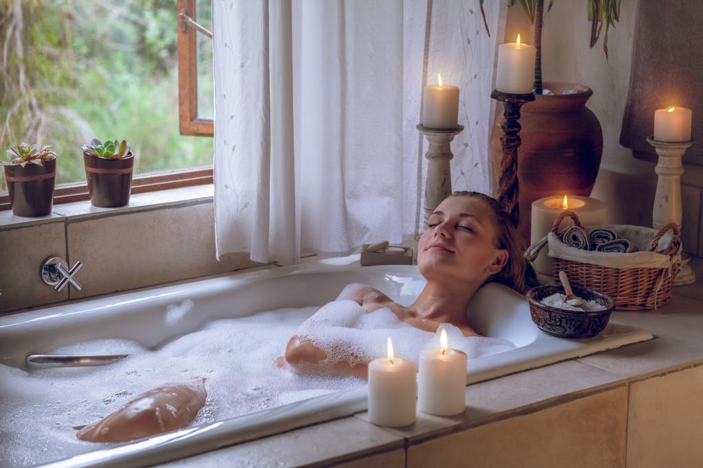 Woman taking a candlelit bath.