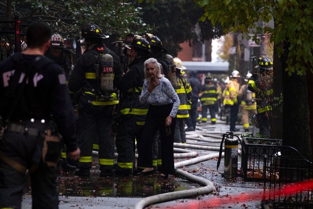 A woman and FDNY firefighters outside a Brooklyn fire.