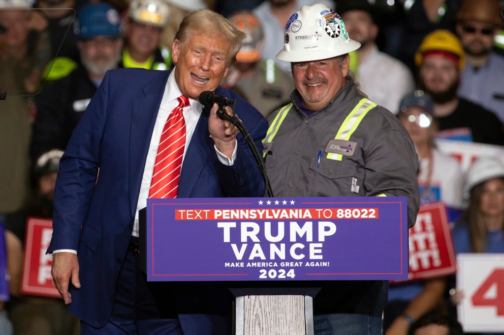 Trump at mic with a man in a hard hat