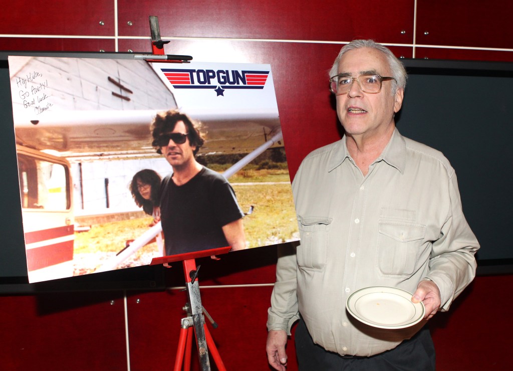 Mike Hechtman at his retirement party at the News Corp building, standing next to a picture, with Rafael Viñoly present