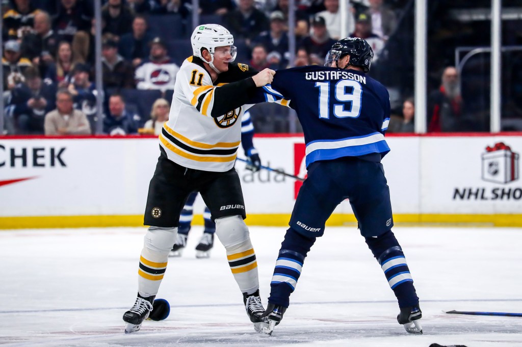 Trent Frederic #11 of the Boston Bruins and David Gustafsson #19 of the Winnipeg Jets fight in the third period on Dec. 10, 2024.