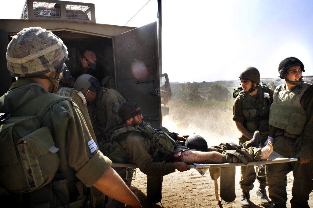 A wounded Israeli soldier is evacuated after he was injured during action against Hezbollah guerillas in south Lebanon near the border village of Maroun al-Ras July 24, 2006. 