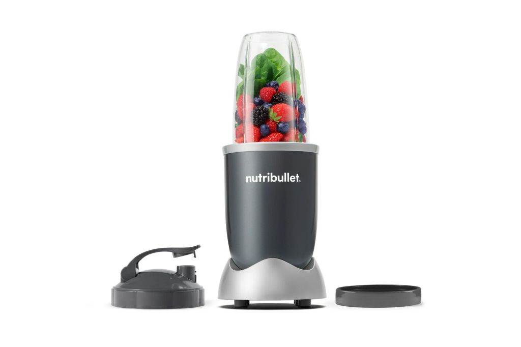 A nutribullet blender with fruits and veggies inside it.