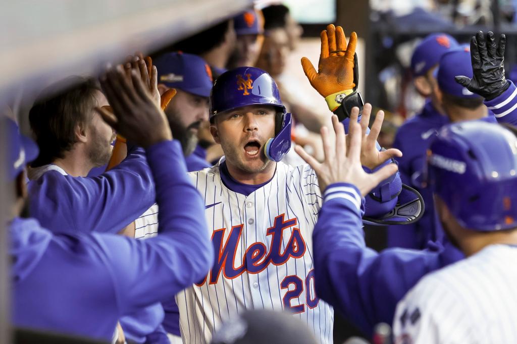 Mets player Pete Alonso celebrating with teammates after hitting a three-run home run during a MLB playoff game against Los Angeles Dodgers