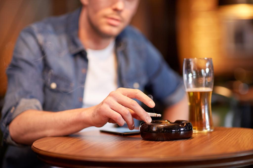 Man smoking with a beer at a bar