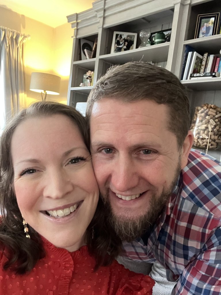 Zoe Gardner-Lawson and her husband smile while taking a selfie together. 