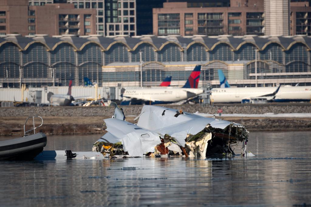 A damaged portion of the fuselage of American Airlines Flight 5342 sticks out of the Potomac River on Jan. 30, 2025.
