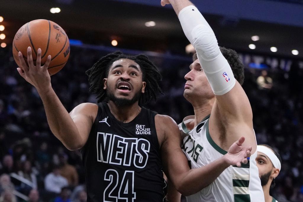 Brooklyn Nets' Cam Thomas shoots past Milwaukee Bucks' Brook Lopez during the first half of an NBA basketball game Thursday, Jan. 2, 2025, in Milwaukee.