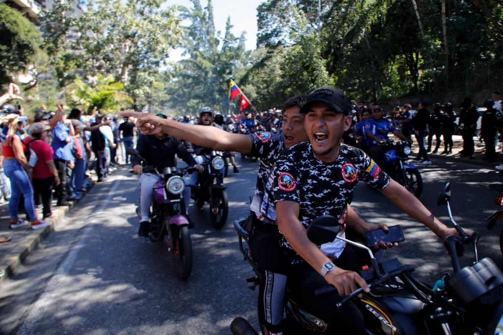 Government supporters shouting at opponents of Venezuelan President Nicolas Maduro, during protests on the day before his inauguration for a third term in Caracas, Venezuela.