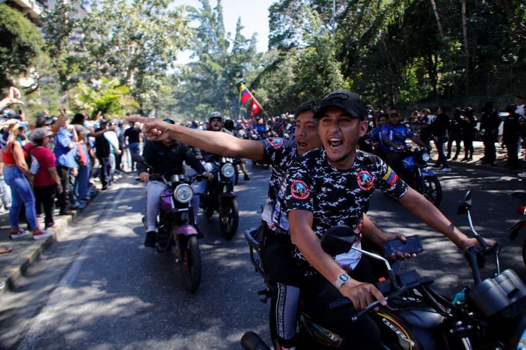 Government supporters shouting at opponents of Venezuelan President Nicolas Maduro, during protests on the day before his inauguration for a third term in Caracas, Venezuela.