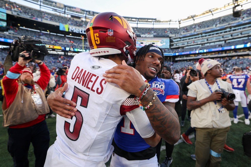 Jayden Daniels #5 of the Washington Commanders and Malik Nabers #1 of the New York Giants embrace after the game at MetLife Stadium on November 3, 2024 in East Rutherford, New Jersey.  