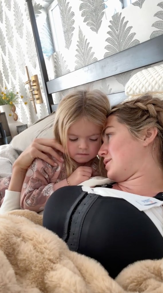 The video ends with Arnold and her two daughters, Sage and June (ages 4 and 1), discussing her new breasts while her husband was on a phone call.