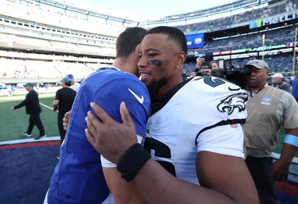 Saquon Barkley #26 of the Philadelphia Eagles hugs Daniel Jones #8 of the New York Giants after the Eagles defeated the Giants 28-3 at MetLife Stadium on October 20, 2024 in East Rutherford, New Jersey.