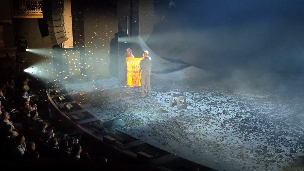 Stop Oil protesters interrupting a performance of The Tempest in London's West End, using a confetti cannon and unfurling a sign referencing global warming.