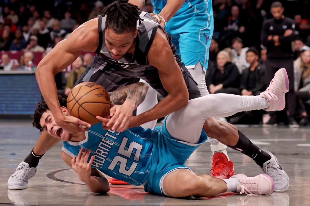 Brooklyn Nets forward Tosan Evbuomwan (12) and Charlotte Hornets guard KJ Simpson (25) fight for the ball during the fourth quarter at Barclays Center. 