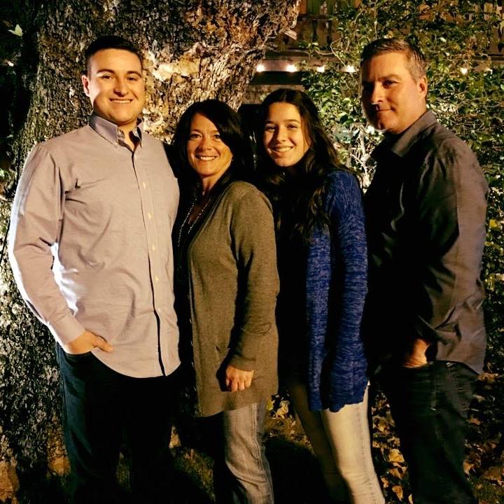 Carter McIntosh with his family standing in front of a tree, embarking on Wall Street career, Charles Rivkin detected in the image