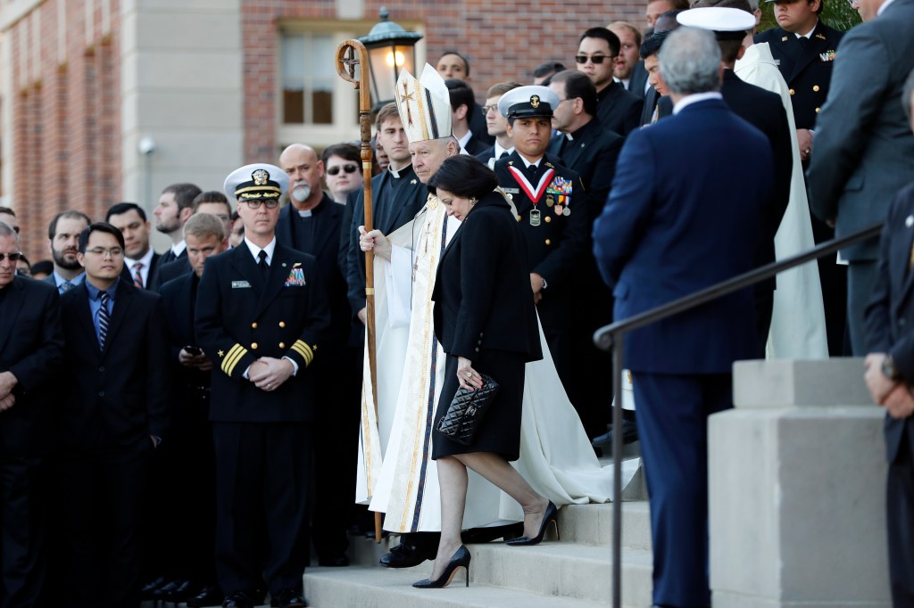 Gayle Benson, widow of NFL New Orleans Saints and NBA New Orleans Pelicans owner Tom Benson, and Archbishop Gregory Aymond receiving Tom Benson's casket at Notre Dame Seminary in New Orleans, 2018.
