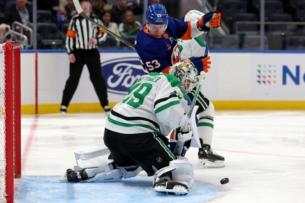Dallas Stars goaltender Jake Oettinger (29) makes a save in front of New York Islanders center Casey Cizikas (53) during the second period at UBS Arena. 