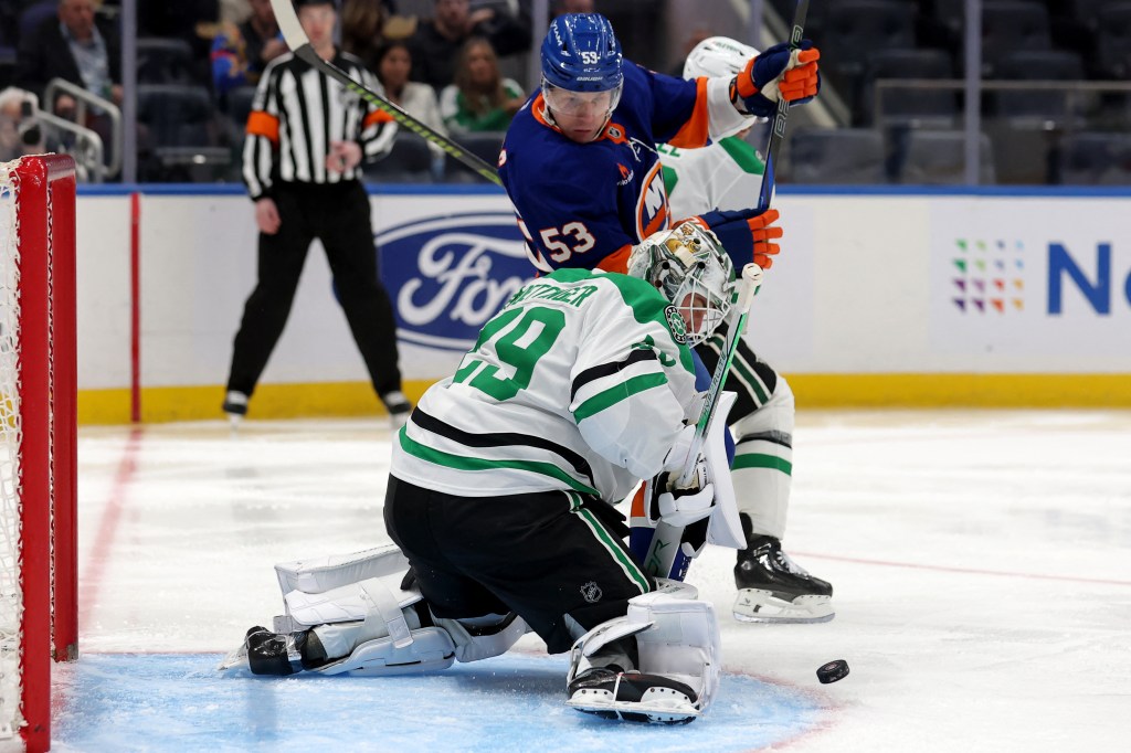 Dallas Stars goaltender Jake Oettinger (29) makes a save in front of New York Islanders center Casey Cizikas (53) during the second period at UBS Arena. 