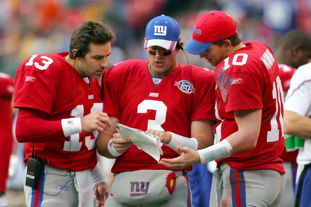 Quarterbacks Kurt Warner #13, Jesse Palmer #10 and Eli Manning #3 of the New York Giants study game formations during the game against the Philadelphia Eagles at Giants Stadium on November 28, 2004 in East Rutherford, New Jersey. The Eagles defeated the Giants 27-6. 