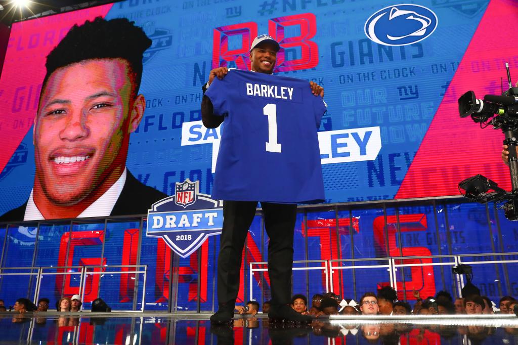 Saquon Barkley poses for photos and holds a New York Giants Jersey as the second overall pick by the New York Giants in the first round at the 2018 NFL Draft at AT&T Statium on April 26, 2018 at AT&T Stadium in Arlington Texas. 