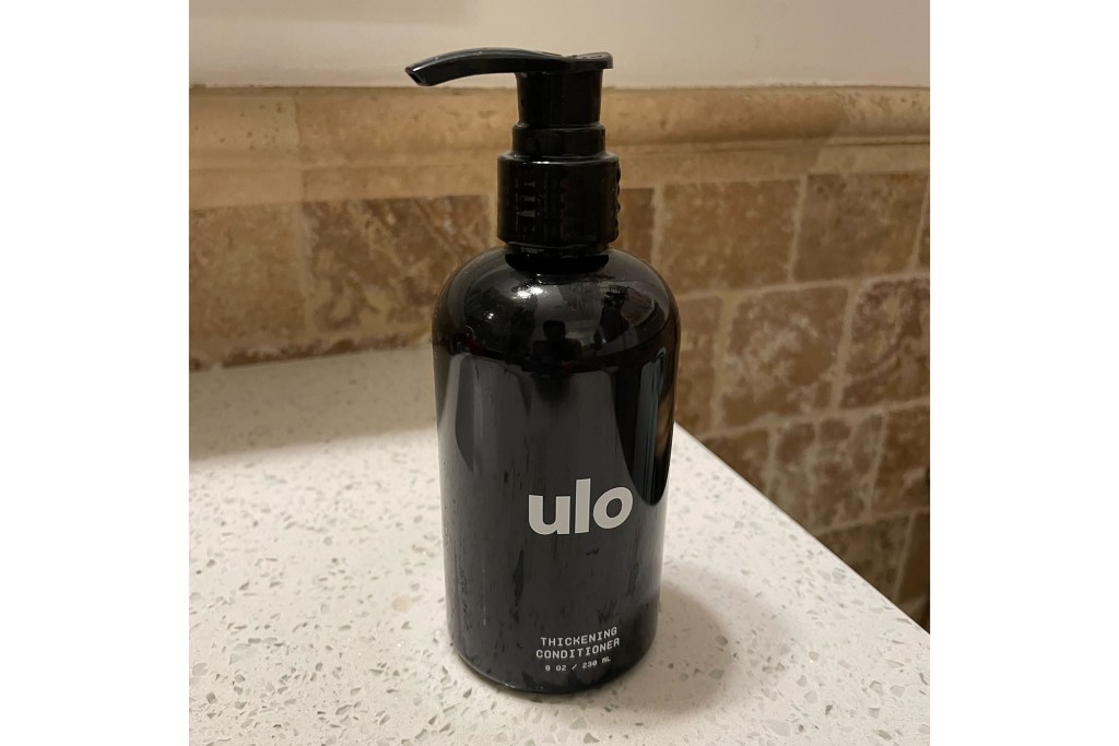 A black Ulo bottle with a dispenser