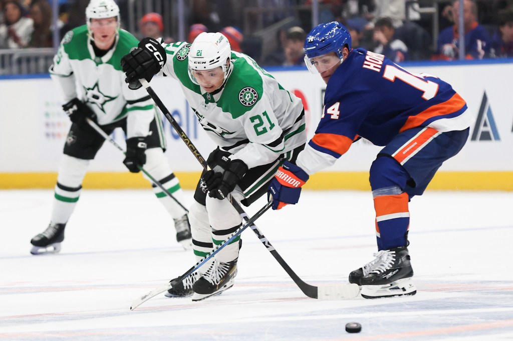 Dallas Stars' Jason Robertson #21 and the Islanders' Bo Horvat battle for the puck during the second period on Feb. 23, 2024. 
