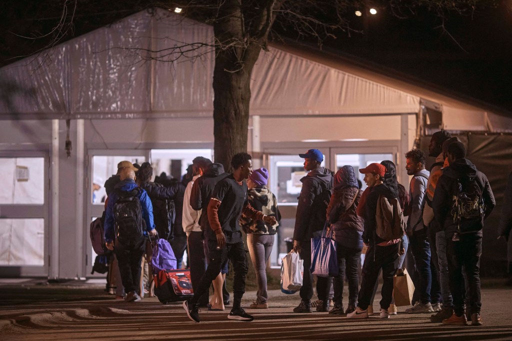 Migrants queue to enter the migrant shelter on Randall's Island, April 9, 2024, in New York.