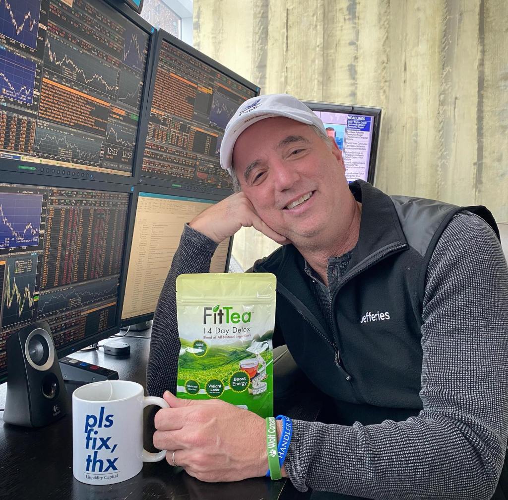 CEO of Jefferies, Richard B. Handler, sitting at a desk with a mug and a bag of tea