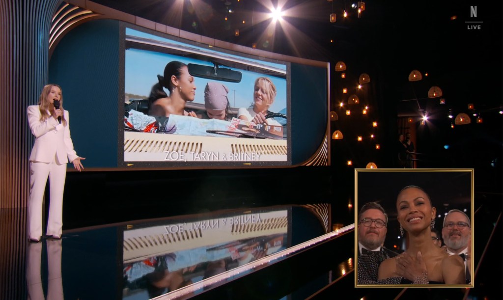 Zoe Saldana reacts to Kristen Bell showing a clip from "Crossroads" during her opening monologue at the 2025 SAG Awards. 
