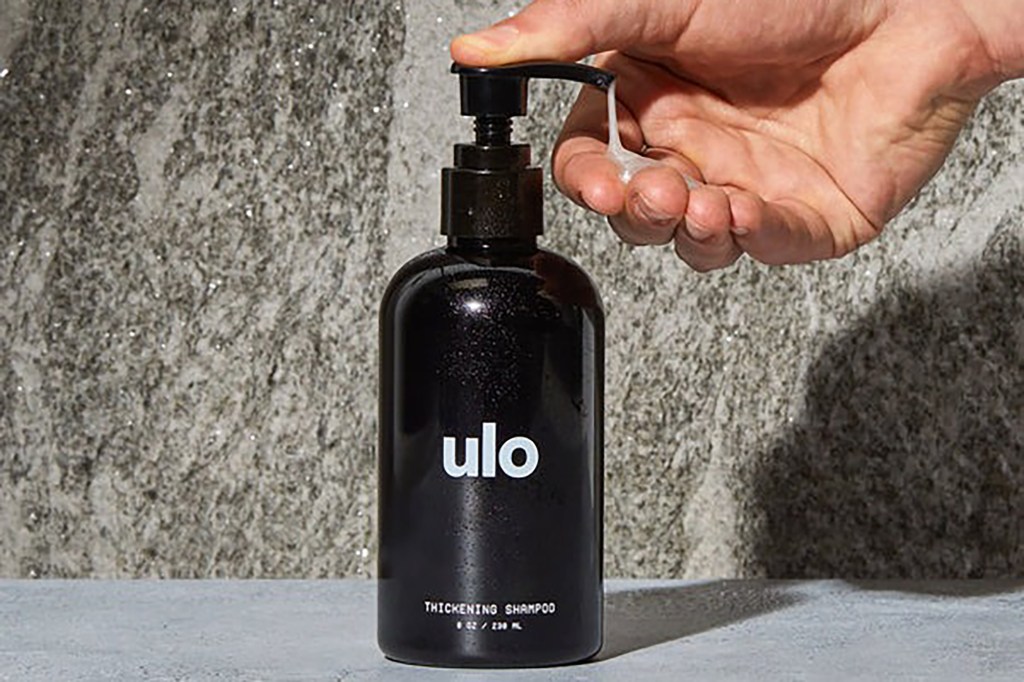A person pouring liquid shampoo into hand