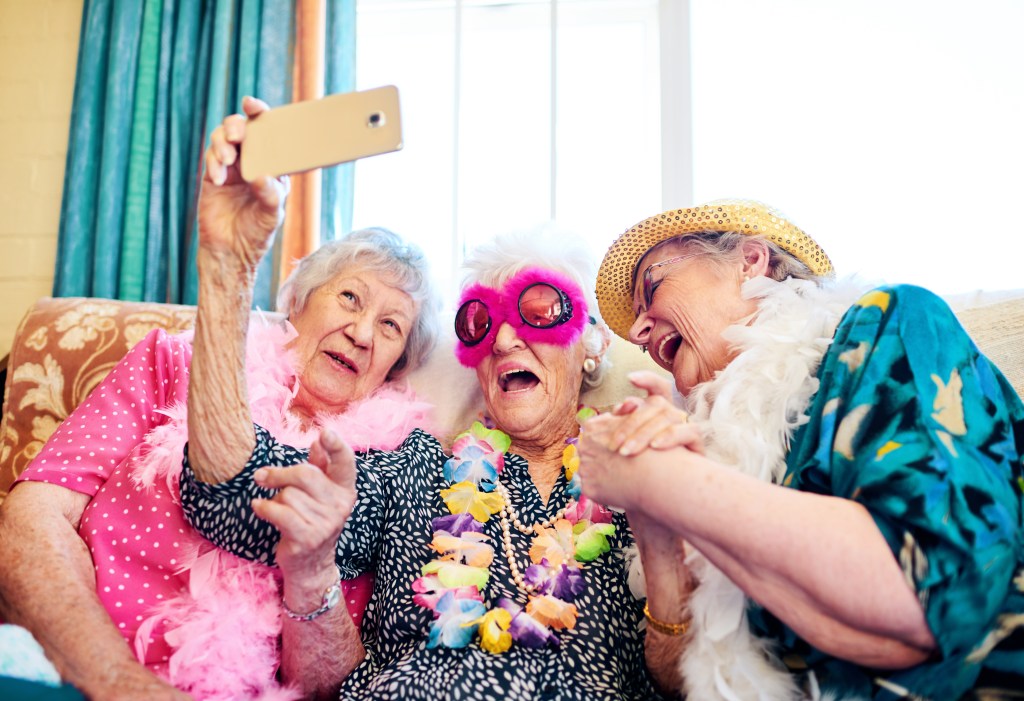 Shot of a group carefree elderly people wearing funky costumes and getting close for a selfie.